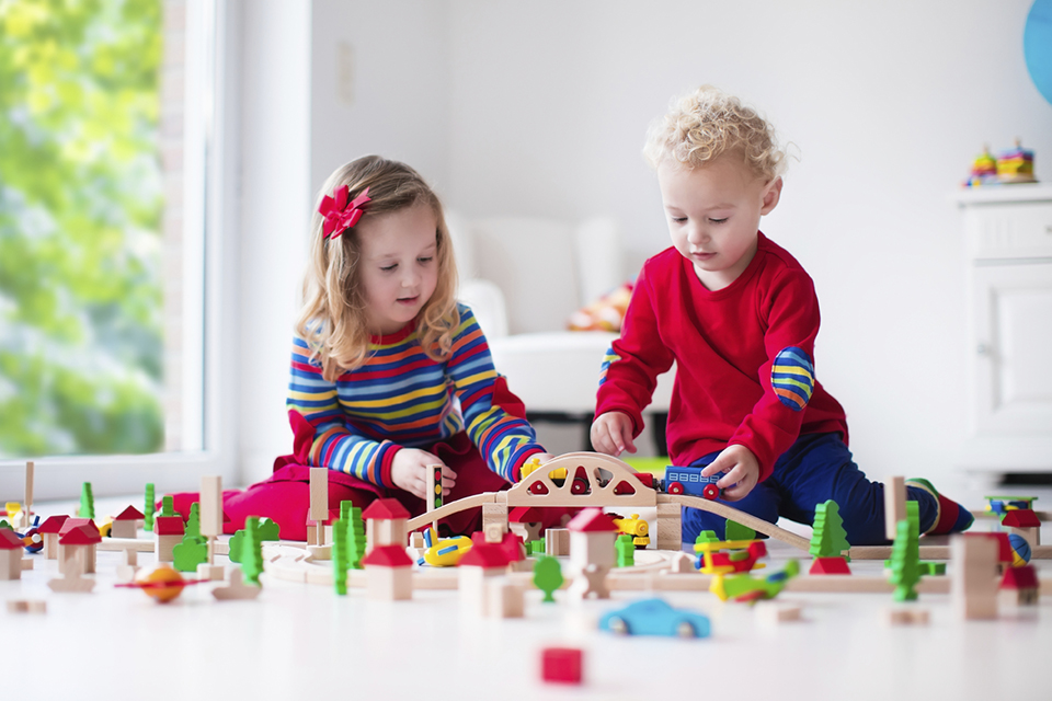 Children playing with toy railroad and train